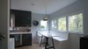 The kitchen is also connected to the front yard, with windows off of the built-in breakfast nook. The breakfast nook offers a casual place to eat, work, or play - while still engaged with what is happening in the kitchen. Photo 7 of Eave House modern home