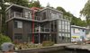 This modern home uses color and siding patterns to help distinguish the house. The large amounts of glazing provide views of the lake from all rooms. Photo 2 of Lake Washington Home modern home