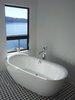 This freestanding tub allows the homeowners to site and enjoy the view during a soak. Photo 5 of Lake Washington Home modern home