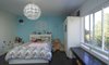 This bedroom feels like an open and spacious haven thanks to the large windows, The clean lines of the built in bench and dresser are sleek without detracting from the overall playfuness of the room. Photo 9 of Mod Remodel modern home