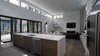 The large kitchen island is perfect area to gather around for special occasions or for daily activities like homework for the kids. There is plenty of built in storage space for storing kitchenware. Photo 3 of Modern Courtyard Home modern home