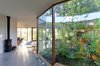 Unlike a conventional structural box with four contiguous shear walls, the two L-shaped storage cores are split apart by the exterior courtyard, creating lateral bracing that carves the loft-like space into alcoves. Photo 18 of The Courtyard House modern home