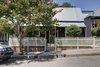 The original cottage sits comfortably within the streetscape, set behind a Crepe Myrtle tree. Photo of Inner West House modern home