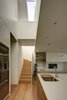 A bridge spans across the two-storey void that cuts across the house, drawing natural light into the interiors and creating connection between ground floor and the upper level. Photo 5 of Inner West House modern home