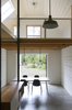 Modern home with Dining Room, Table, Chair, Storage, Concrete Floor, Ceiling Lighting, and Pendant Lighting. This former garage is now converted into a large open space. The dining room opens onto the residence garden and an office space overlooks the living room. Photo 3 of L'Eau Vive