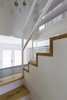Modern home with Staircase, Metal Tread, Wood Tread, and Metal Railing. The staircase was built from the wooden beams that belonged to the structure of the ancestral floor. The stairs also integrate a library that goes from the bottom of the steps to the ceiling. Photo 7 of L'Eau Vive