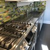 Modern home with Kitchen, Granite Counter, White Cabinet, Glass Tile Backsplashe, Dishwasher, Range, and Drop In Sink. An eye popping combination of glass tiles in shades of green, yellow, and orange with stainless steel tile accents is stunning in this sleek modern kitchen.
Shop this tile! http://www.susanjablon.com/5290754.html Photo of Steel Bamboo With Orange Glass Tile Backsplash