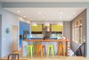 Modern home with Kitchen, Quartzite Counter, Wood Counter, Colorful Cabinet, Laminate Cabinet, Medium Hardwood Floor, Pendant Lighting, Recessed Lighting, Refrigerator, Range, Range Hood, Microwave, and Undermount Sink. Kitchen Photo 7 of Panavista Hill House