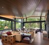 Modern home with Living Room, Medium Hardwood Floor, Recessed Lighting, Lamps, Sofa, Floor Lighting, Table Lighting, End Tables, and Chair. The living room opens, a glass-enclosed perch located at the house’s highest point, connects to nature with views looking into the tree canopy. The floating folded roof plain move through the space. Photo 4 of Woody Creek Residence