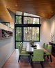 Modern home with Dining Room, Table, Medium Hardwood Floor, and Chair. The dining room was envisioned as an “eddy” in the circulation path. Folded planes of the ceiling intersect above the dining room, the corner lifts to allow more light and view of the cottonwoods by the creek. Photo 5 of Woody Creek Residence