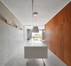 Modern home with Kitchen, Wall Lighting, Refrigerator, Ceiling Lighting, White Cabinet, Concrete Floor, Drop In Sink, and Engineered Quartz Counter. Kitchen volume along Laundry/ WC wooden volume Photo 5 of The Marina Apartment