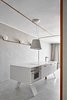 Modern home with Kitchen, Concrete Backsplashe, Concrete Floor, Engineered Quartz Counter, White Cabinet, Wall Lighting, Wall Oven, Drop In Sink, Microwave, and Wine Cooler. Corian Countertop, Arredo3 Kitchen cabinets and custome made legs Photo 7 of The Marina Apartment