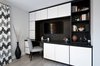 The home office area was meant to be a refuge and the place where our client would spend a lot of time both working and relaxing. It needed to be bright and airy, modern, but comfortable.
The main focal point of the room is a custom designed and built wall unit, with desk and cabinet mounted television. The 2 tone contrast of the unit adds depth to the wall. There is also a built-in under counter refrigerator and file drawers for storage.
Photo 2 of West Coast Pied A Terre modern home