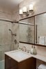 The small bathroom was tiled from ceiling to floor with a light, stone looking, porcelain tile. Using borders around the room added detail and neutral color to the space. The custom vanity was created with exotic woods, and topped off with a marble stone countertop. Photo 5 of Dog Lover's Apartment modern home