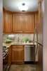 The kitchen, although small, packs a lot of storage punch! Going for a warmer more rustic look here, we used a tumble marble for the backsplash with inserts of a copper decorative tile that we placed throughout.
Photo of Dog Lover's Apartment modern home