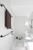 The bright, monochromatic bathroom with sunken tub provides a sense of tranquility and calm for the family. Photo 8 of Enmore House modern home