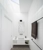 The ensuite bathroom shares a angular skylight with the main bedroom - allowing views to the sky and providing bountiful natural light. Photo 9 of Enmore House modern home