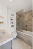 In the bathroom, the homeowner chose to continue the marble theme with herringbone floors, a warm subway tile on the walls, and the same 2-inch-thick Carrara marble from the kitchen as a counter. With a frameless glass divider, the deep soaking tub does double duty for baths and showers. Three well-placed niches, including one inside the tub area, add storage for toiletries and small décor objects. Photo 6 of A Greenwich Village Loft Gets a Makeover modern home
