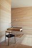 Modern home with Office, Chair, and Light Hardwood Floor. A cantilevered birch and plywood desk appears to effortlessly float in midair. The wood box is attached to the wall with a blackened structural steel angle. “It’s a place to make a phone call, put down keys, plug in the iPhones,” says Ryall. “We liked the contrast of the structural steel and the more refined wood box, kind of the like the house, which itself is full of contrasts—rough/smooth, dark/light, open/closed.” Photo 4 of Orient House V
