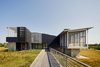 Modern home with Exterior, Flat RoofLine, House Building Type, Shed RoofLine, and Wood Siding Material. Concrete walls support the living space and elevate it from storm surges. Photo 13 of Orient House V