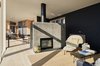 Modern home with Chair and Light Hardwood Floor. In the living room, the design team poured concrete in place using smooth board formwork to create the seamless fireplace. Photo 11 of Orient House V