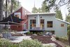Modern home with Outdoor, Back Yard, Garden, Woodland, Slope, Trees, Shrubs, Hardscapes, Walkways, Large Patio, Porch, Deck, Boulders, Decking Patio, Porch, Deck, Pavers Patio, Porch, Deck, Stone Patio, Porch, Deck, and Metal Patio, Porch, Deck. View at rear with breezeway, deck, and tensile structure Photo 2 of The Frederick McKeehan Residence