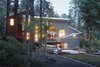 Modern home with Dark Hardwood Floor, Stone Tile Backsplashe, Pendant Lighting, Wood Cabinet, Wall Oven, Range, Microwave, Ceiling Lighting, Dishwasher, Refrigerator, Range Hood, Undermount Sink, Outdoor, Front Yard, Back Yard, Garden, Shrubs, Hardscapes, Gardens, and Trees. View at rear Photo of The Frederick McKeehan Residence
