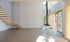 Modern home with Living Room, Ceiling Lighting, Hanging Fireplace, Corner Fireplace, Recessed Lighting, and Light Hardwood Floor. Double height living room with floating stair and fire place Photo of Bay View House
