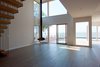Modern home with Living Room, Hanging Fireplace, Light Hardwood Floor, Ceiling Lighting, and Recessed Lighting. Double height living room Photo 2 of Bay View House