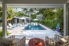 Modern home with Outdoor, Back Yard, Garden, Trees, Shrubs, Hardscapes, Gardens, Large Pools, Tubs, Shower, Plunge Pools, Tubs, Shower, Lap Pools, Tubs, Shower, Walkways, Swimming Pools, Tubs, Shower, Standard Construction Pools, Tubs, Shower, Large Patio, Porch, Deck, Tile Patio, Porch, Deck, and Pavers Patio, Porch, Deck. The view from the guesthouse allows friends and family to be part of the outdoor area while still having their own space. The knee wall behind the pool creates a division in the garden allowing the owners to have their own private patio space off of the Master Suite. Photo 6 of Modernist Retreat