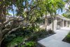Modern home with Outdoor, Back Yard, Trees, Shrubs, Gardens, Garden, Hardscapes, Walkways, Small Patio, Porch, Deck, and Concrete Patio, Porch, Deck. The design was based around the existing lignum vitae with tropical underplanting, it separates the driveway and the guesthouse. Photo 4 of Modernist Retreat
