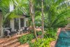 Modern home with Outdoor, Back Yard, Shrubs, Garden, Trees, Gardens, Hardscapes, Walkways, Large Pools, Tubs, Shower, Swimming Pools, Tubs, Shower, Plunge Pools, Tubs, Shower, Standard Construction Pools, Tubs, Shower, Lap Pools, Tubs, Shower, Large Patio, Porch, Deck, Pavers Patio, Porch, Deck, and Landscape Lighting. The coping of the pool was raised, as the owners wanted the property to feel as though it was spilt in half, allowing the guesthouse to feel separate and private from the main house. Photo 9 of Key West Classic