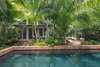 Modern home with Outdoor, Back Yard, Garden, Trees, Hardscapes, Shrubs, Gardens, Walkways, Large Pools, Tubs, Shower, Lap Pools, Tubs, Shower, Swimming Pools, Tubs, Shower, Plunge Pools, Tubs, Shower, Standard Construction Pools, Tubs, Shower, Large Patio, Porch, Deck, Pavers Patio, Porch, Deck, and Landscape Lighting. A view from the garden side of the guesthouse shows the main house is visible yet the pool creates a division and strategic planting helps to create privacy between the two spaces. Photo 11 of Key West Classic
