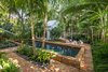 Modern home with Outdoor, Back Yard, Trees, Shrubs, Garden, Gardens, Walkways, Hardscapes, Large Pools, Tubs, Shower, Plunge Pools, Tubs, Shower, Lap Pools, Tubs, Shower, Swimming Pools, Tubs, Shower, Standard Construction Pools, Tubs, Shower, Pavers Patio, Porch, Deck, Landscape Lighting, and Large Patio, Porch, Deck. The coping of the pool was raised, as the owners wanted the property to feel as though it was spilt in half, allowing the guesthouse to feel separate and private from the main house. Tall palms were used for their canopies and plantings were done by groupings of the same varieties to help the garden feel open and spacious. Photo 10 of Key West Classic