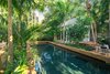 Modern home with Outdoor, Garden, Back Yard, Hardscapes, Gardens, Walkways, Trees, Large Pools, Tubs, Shower, Shrubs, Standard Construction Pools, Tubs, Shower, Large Patio, Porch, Deck, Swimming Pools, Tubs, Shower, Pavers Patio, Porch, Deck, and Landscape Lighting. Separated by a swimming pool allows the clients' guest to feel as though they have their own private tropical lagoon. Photo 12 of Key West Classic