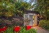 A dynamic entrance to the garden framed by mass plantings and bright sculptural containers sets the scene for the tropical garden behind the doors. Photo 13 of Von Phister modern home