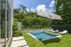 Modern home with Outdoor, Back Yard, Hardscapes, Walkways, Shrubs, Trees, Grass, Raised Planters, Small Pools, Tubs, Shower, Plunge Pools, Tubs, Shower, Standard Construction Pools, Tubs, Shower, Concrete Patio, Porch, Deck, Small Patio, Porch, Deck, and Landscape Lighting. Swimming pool with a water feature, clean lines, minimal planting and poured in place concrete used to mimic the shape of the home. Photo 9 of Tropical Minimal
