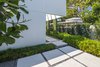 Modern home with Outdoor, Side Yard, Trees, Hardscapes, Front Yard, Walkways, Shrubs, Landscape Lighting, and Concrete Patio, Porch, Deck. Poured in place concrete was used to mimic the structure of the home and the slight step up to to further emphasize the fact that one was entering into a different space. Photo 2 of Tropical Minimal