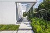Modern home with Outdoor, Shrubs, Hardscapes, Side Yard, Garden, Walkways, Concrete Patio, Porch, Deck, and Landscape Lighting. Poured in place concrete was used to mimic the structure of the home and the slight step up to to further emphasize the fact that one was entering into a different space. Planting was kept to minimal species and in groupings. Photo 3 of Tropical Minimal