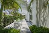 Modern home with Outdoor, Shrubs, Trees, Side Yard, Walkways, Hardscapes, Landscape Lighting, and Concrete Patio, Porch, Deck. Indoor/outdoor living is a must in Key West. The main design philosophy of the overall design was to create areas outside that acted as their own special spaces and were an extension of the inside. Photo 4 of Tropical Minimal