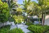 Modern home with Outdoor, Side Yard, Back Yard, Hardscapes, Walkways, Shrubs, Small Patio, Porch, Deck, Gardens, Trees, Concrete Patio, Porch, Deck, and Landscape Lighting. The clients had very specific priorities with their dream tropical garden and a fire pit was high on the list of priorities. Photo 7 of Tropical Minimal
