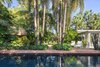 Modern home with Outdoor, Back Yard, Side Yard, Garden, Trees, Gardens, Shrubs, Hardscapes, Walkways, Small Pools, Tubs, Shower, Standard Construction Pools, Tubs, Shower, Swimming Pools, Tubs, Shower, Small Patio, Porch, Deck, Pavers Patio, Porch, Deck, and Landscape Lighting. Existing palms lined the existing path to the swimming pool but the use of the brick pavers and matching pool coping with the same material allows the space to have more of an open, airy feel. Photo 7 of Fred's Garden