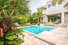 Modern home with Outdoor, Trees, Front Yard, Hardscapes, Shrubs, Walkways, Small Pools, Tubs, Shower, Standard Construction Pools, Tubs, Shower, Swimming Pools, Tubs, Shower, Pavers Patio, Porch, Deck, Large Patio, Porch, Deck, Landscape Lighting, and Garden. A secondary step-up was created to add height to make up the grade. The water fountain was added to the pool with a ledge directly underneath to sit on so the water could spill onto the home owners or it could function as a visual feature while the sound of the running water could be enjoyed whether or not they were relaxing in or by the pool. The original property had the swimming pool at the front of the house and the decision was made that it would remain in the same place so the clients could get the effect of walking over water when they enter their home. Photo 3 of Key West Modern