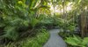 Modern home with Outdoor, Garden, Walkways, Gardens, Hardscapes, Trees, Shrubs, Back Yard, and Landscape Lighting. The clients requested a tropical garden they could walk through. The gravel pathway helps add to the sense of a tropical jungle. Photo 14 of Key West Modern