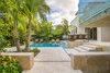 Modern home with Outdoor, Shrubs, Trees, Raised Planters, Side Yard, Hardscapes, Small Pools, Tubs, Shower, Walkways, Swimming Pools, Tubs, Shower, Standard Construction Pools, Tubs, Shower, Large Patio, Porch, Deck, Pavers Patio, Porch, Deck, Landscape Lighting, and Garden. A low wall was built to create a distinct separation of space between the carport and the entrance to the house with the sense of entering into a resort. Photo 11 of Key West Modern
