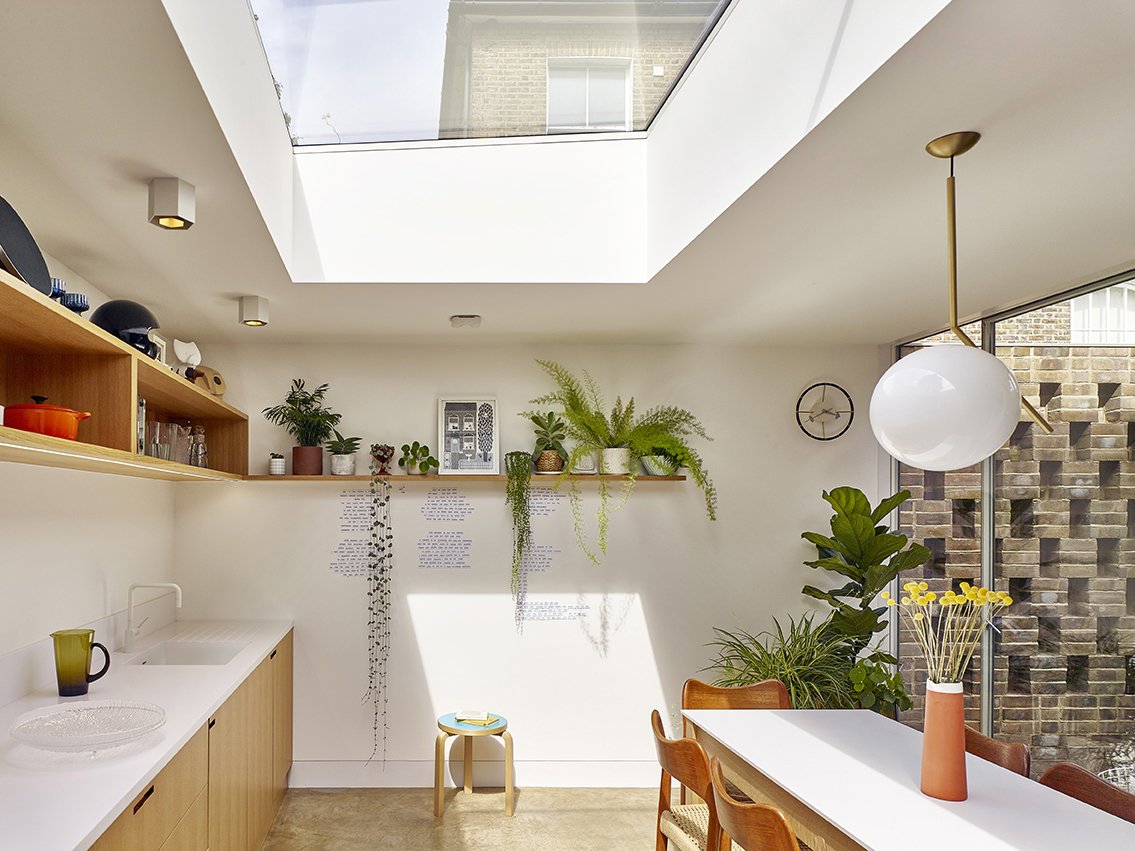 In the combined kitchen and dining room, a skylight lets in lots of sunlight, and the table overlooks the courtyard.
