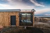 Modern home with Exterior, Wood Siding Material, Metal Roof Material, Cabin Building Type, Tiny Home Building Type, and Gable RoofLine. The cabin is located in Hvalfjörður, Iceland, just a 30-minute drive from Reykjavík, and can only be accessed by car. The area is remote, private, and quiet, making it ideal for viewing the Northern Lights at night, as well as hiking during the day. Photo 2 of Panorama Glass Lodge
