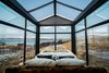 Modern home with Bedroom and Bed. The custom-made king-sized bed is dressed with luxury duvets from Böhmerwald, Bavaria, and fluffy linen from Schlafgut, Germany. There are window blinds for the walls if more privacy is needed, while the glass roof remains exposed to the sky. Photo of Panorama Glass Lodge