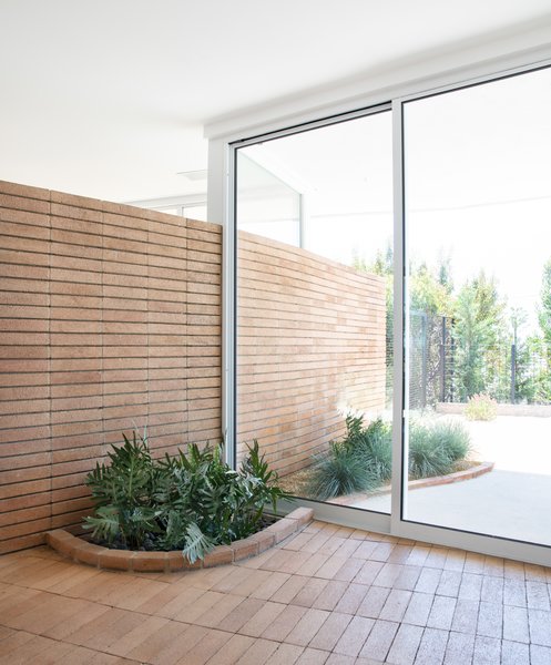 Restored original brickwork and a built-in planter at the entry.