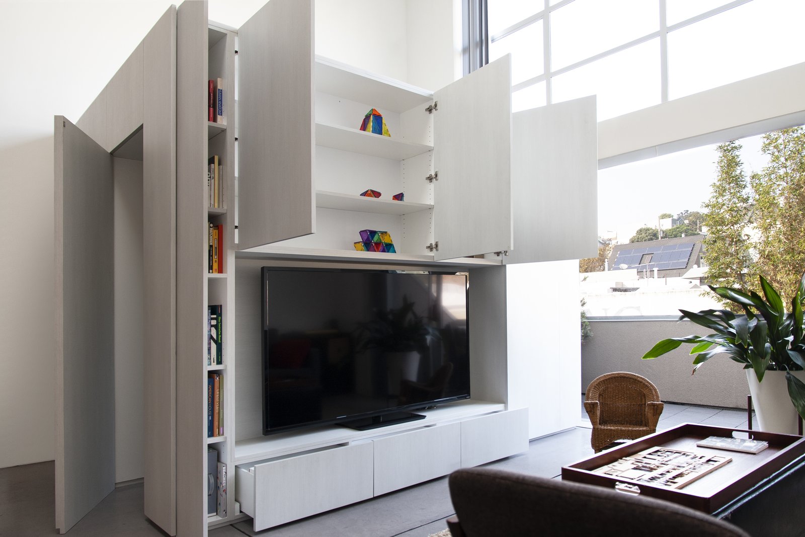 A glimpse of the storage capabilities now provided by the cabinet room. "The loft came with little storage," says Knayzeh. "We needed to have the ability to hide general mess when we have company." Integrated cabinets in the walls of the room now provide a coat closet, document filing, and space for Knayzeh's book collection around the perimeter.